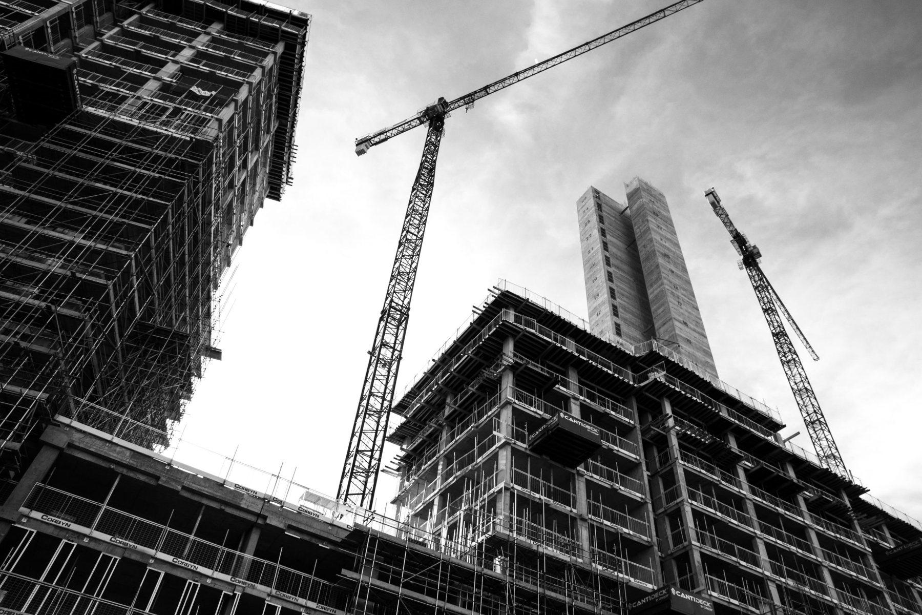 Black-and-white photograph of cranes and buildings under construction